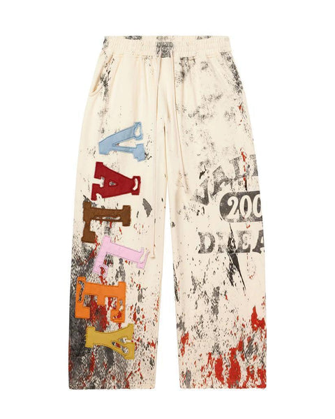 Pants with colorful text and abstract patterns on a white background