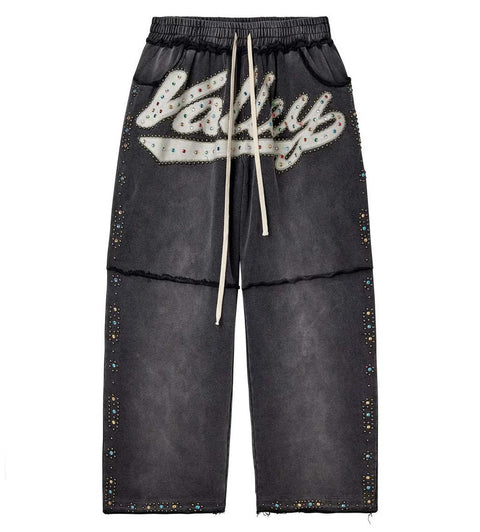 Black pants with 'Valley' logo and rhinestone embellishments on a white background